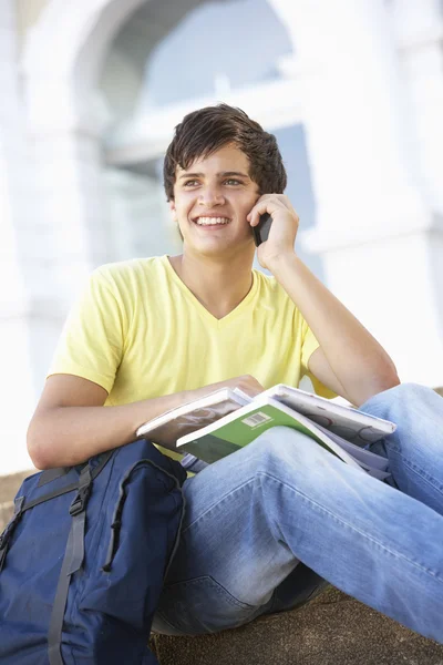 Manlig teenage student sitter utanför på college stegen med mobi — Stockfoto
