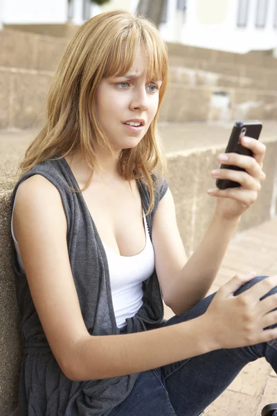 Mujer infeliz adolescente estudiante sentado fuera en la universidad pasos —  Fotos de Stock