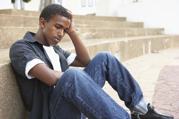 Infelice maschio adolescente studente seduta al di fuori su college passi — Foto Stock