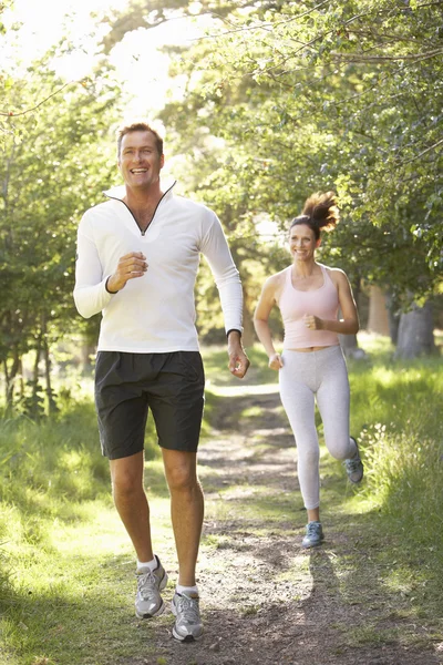 Paar mittleren Alters joggt im Park — Stockfoto
