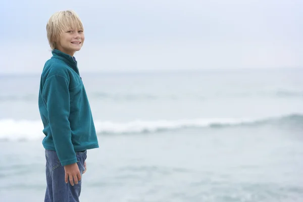 海を見渡す冬ビーチで休日立って上の少年 — ストック写真
