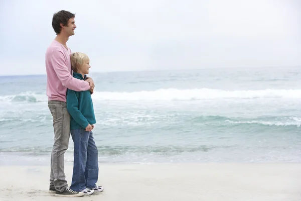 Vader en zoon permanent op winter strand samen — Stockfoto