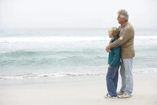 Дедушка и сын, стоящие на Зимнем пляже вместе — стоковое фото