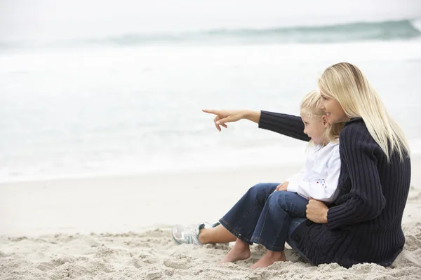 母亲和女儿坐在冬季海滩上的假期 — 图库照片