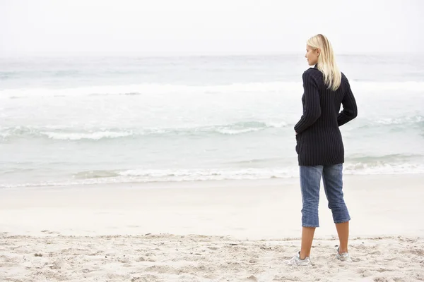 年轻的女子在假日站在冬季海滩上 — 图库照片