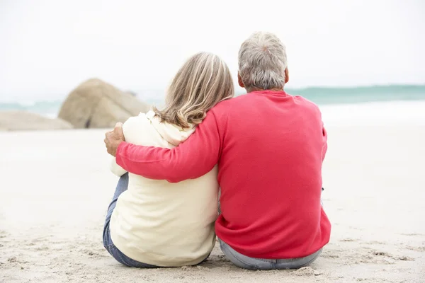 Idősebb pár ül a téli beach holiday — Stock Fotó