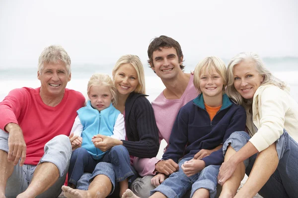 3 世代家族は一緒に冬のビーチに座って — ストック写真