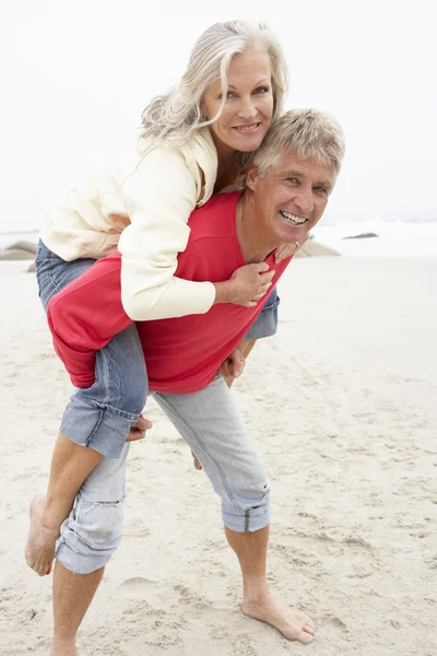 Starší Muž Dává Žena Složená Zimní Beach — Stock fotografie