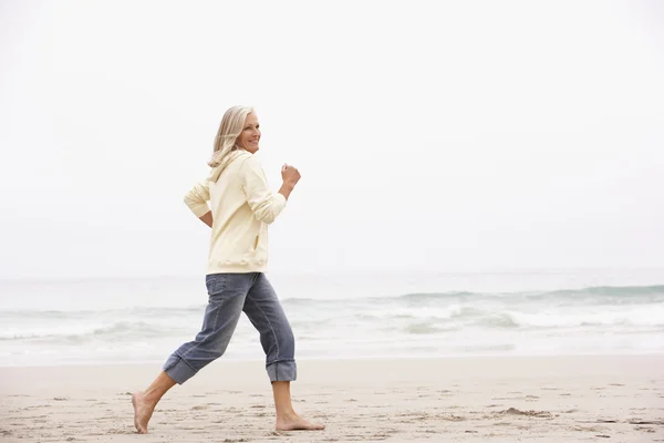 Ανώτερος Γυναίκα Στις Διακοπές Που Τρέχει Κατά Μήκος Της Παραλίας — Φωτογραφία Αρχείου