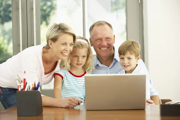 Familia usando el ordenador portátil en casa — Foto de Stock