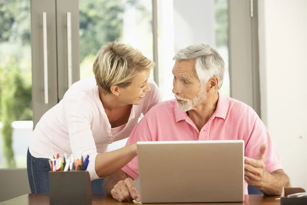 家中使用笔记本电脑的成年女儿及年长父亲 — 图库照片