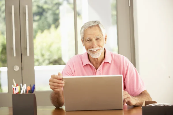 Uomo anziano che utilizza il computer portatile a casa — Foto Stock