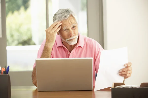 Senior muž pomocí notebooku doma — Stock fotografie