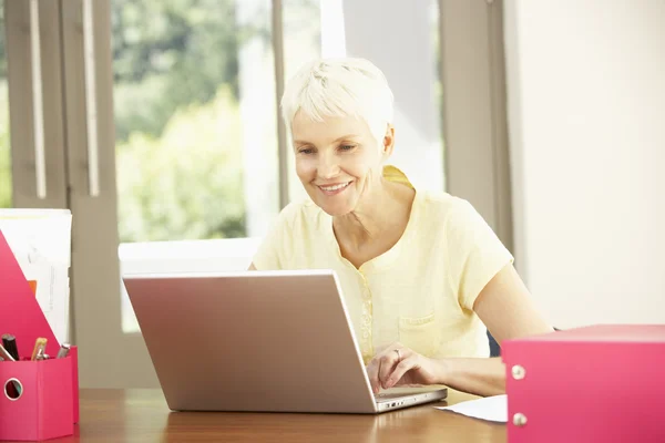 Senior kvinna som använder laptop hemma — Stockfoto