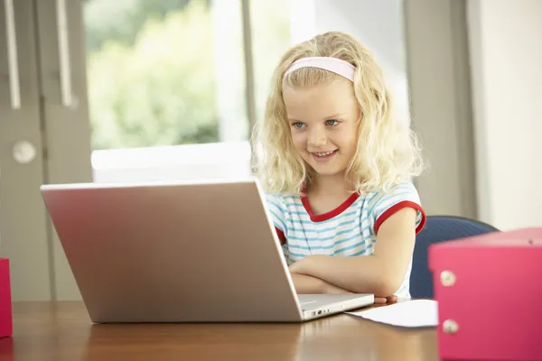 Jong meisje met behulp van laptop thuis — Stockfoto