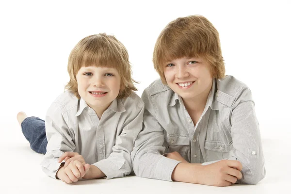 Two Young Boys Lying Stomach Studio Stock Photo