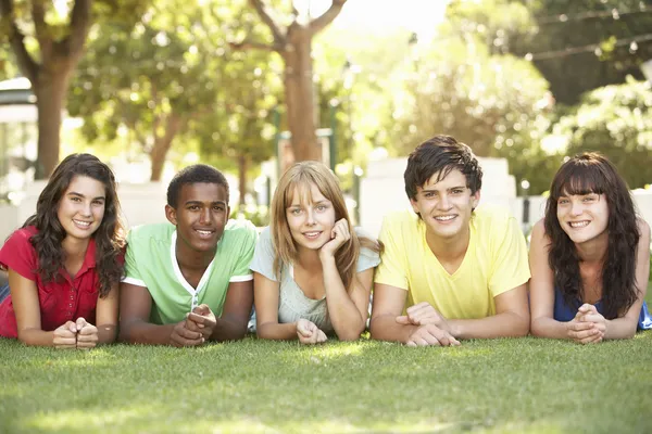 Group Of Teenagers Lying On Stomachs In Park Royalty Free Stock Photos