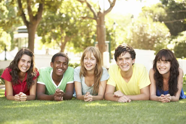 Group Of Teenagers Lying On Stomachs In Park Stock Picture