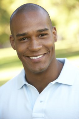 Portrait Of Young Man Sitting In Park clipart