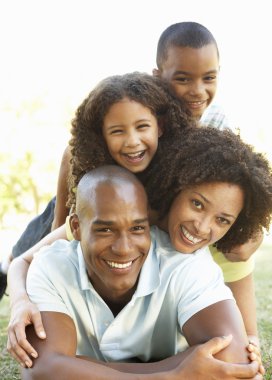 Portrait of Happy Family Piled Up In Park clipart