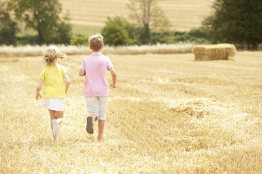 Children Running Through Summer Harvested Field clipart