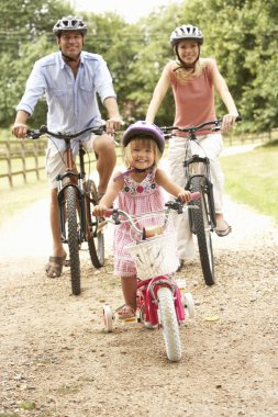 Family Cycling In Countryside Wearing Safety Helmets clipart