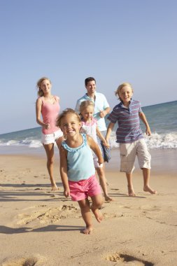 Portrait Of Running Family On Beach Holiday clipart