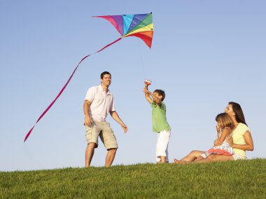 Young family, parents with children, playing in a field clipart