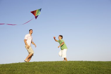 Young parent, father with child, playing in a field clipart