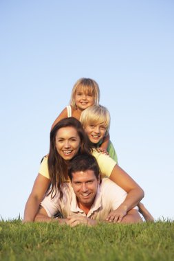 Young parents, with children, posing on a field clipart