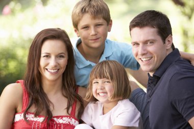 Portrait Of Young Family Relaxing In Park clipart