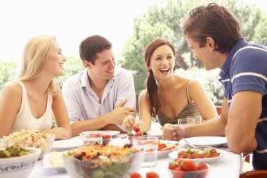 Two young couples eating outdoors clipart