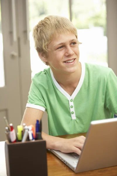 Adolescent garçon en utilisant ordinateur portable à la maison — Photo