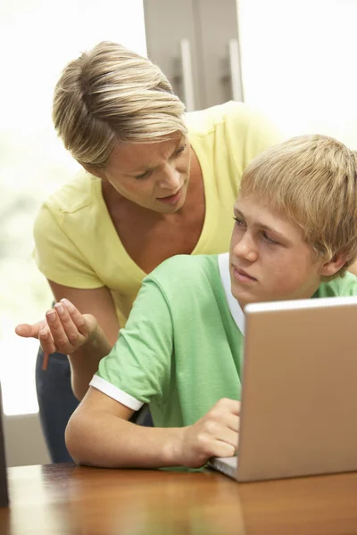 Vztek matka a dospívající syn doma pomocí přenosného počítače — Stock fotografie