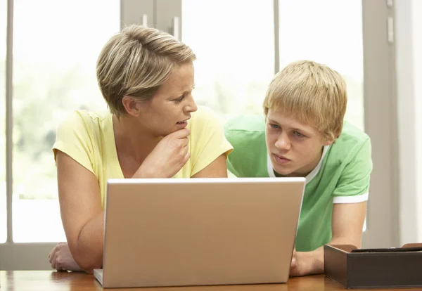 Madre e hijo adolescente usando el ordenador portátil en casa — Foto de Stock