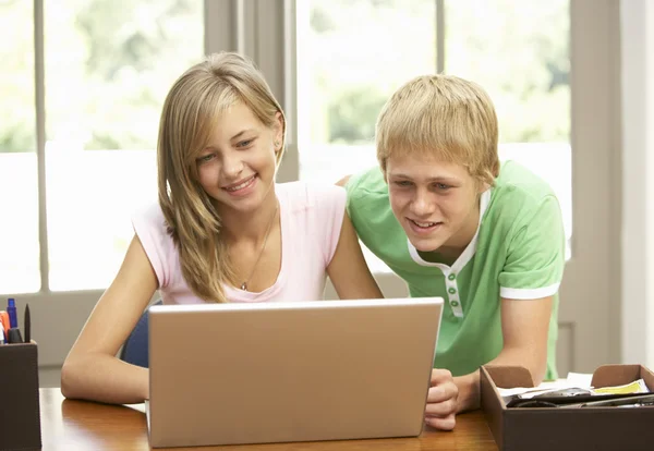 Два подростка используют ноутбук дома — стоковое фото