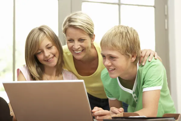 母亲和十几岁的孩子在家中使用的笔记本电脑 — 图库照片