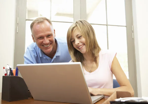 Отец и дочь-подросток используют ноутбук дома — стоковое фото