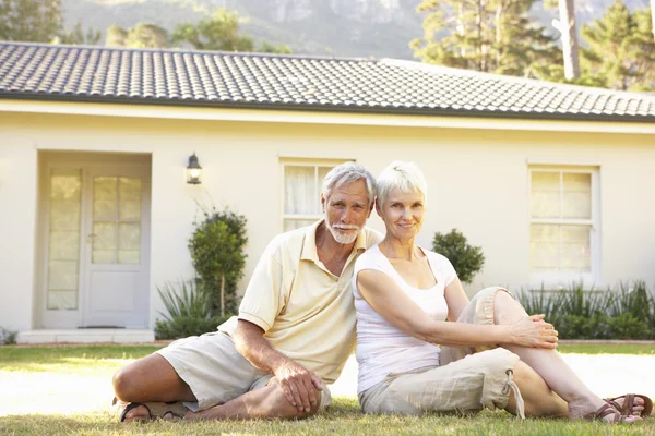 Äldre par sitter utanför drömhus — Stockfoto