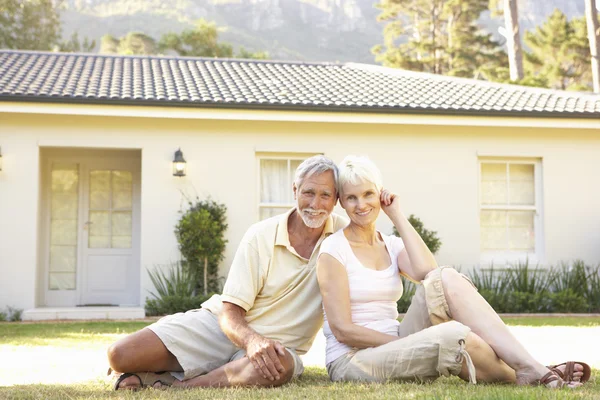 Seniorenpaar Sitzt Vor Traumhaus — Stockfoto