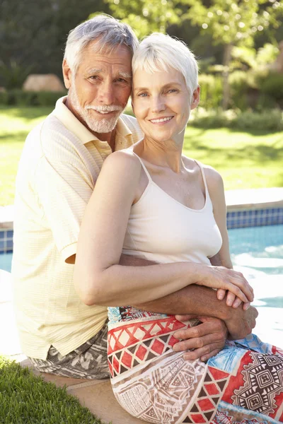 Seniorenpaar entspannt sich am Pool im Garten — Stockfoto