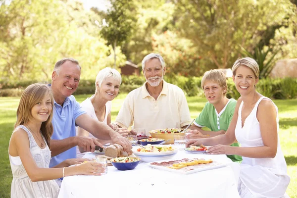 Großfamilie genießt Essen im Garten — Stockfoto