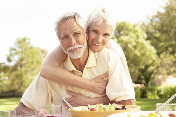 Äldre par njuter av måltid i trädgården — Stockfoto