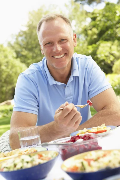 Homem desfrutando refeição no jardim — Fotografia de Stock