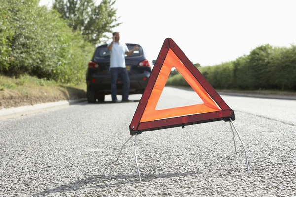 Conductor roto en la carretera del campo con señal de advertencia de peligro en F — Foto de Stock
