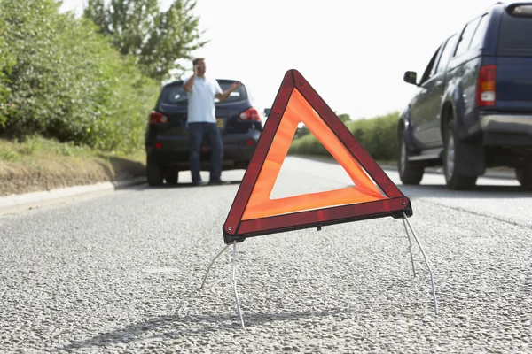 驱动程序与危险警告标志 国家道路上细分 — 图库照片