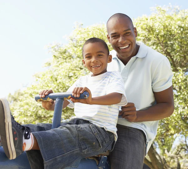 父亲和儿子骑在公园跷跷板 — 图库照片