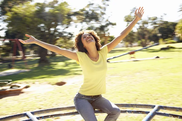 공원 회전 목마를 타고 젊은 여자 — 스톡 사진