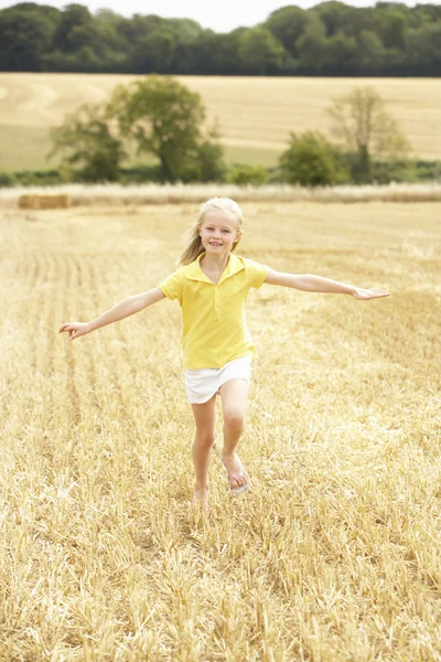 Chica corriendo a través de verano cosechado campo — Foto de Stock
