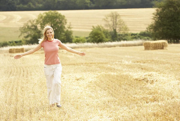 Mulher correndo através de campo colhido verão — Fotografia de Stock